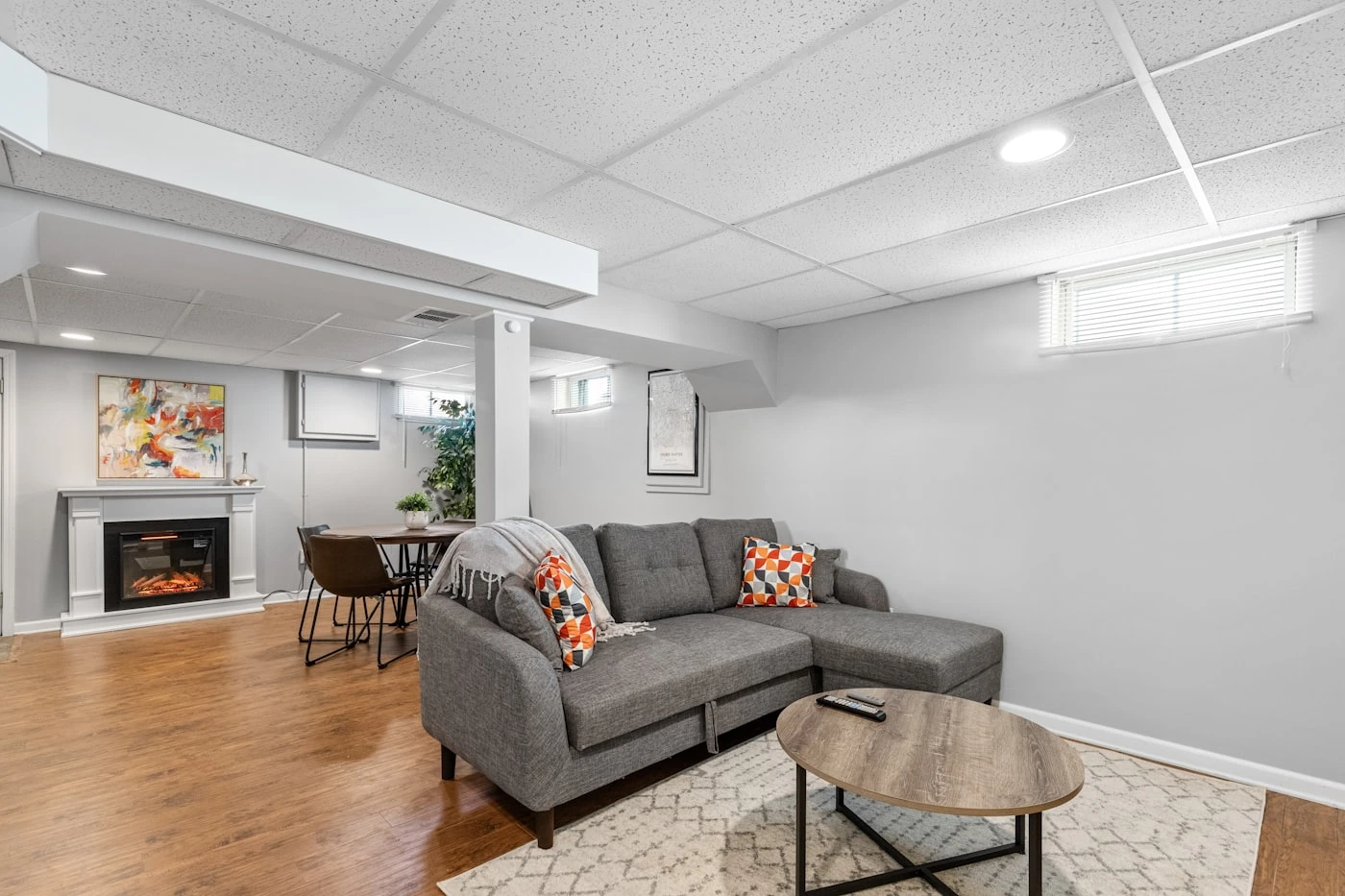 Finished basement living space with sectional sofa and fireplace